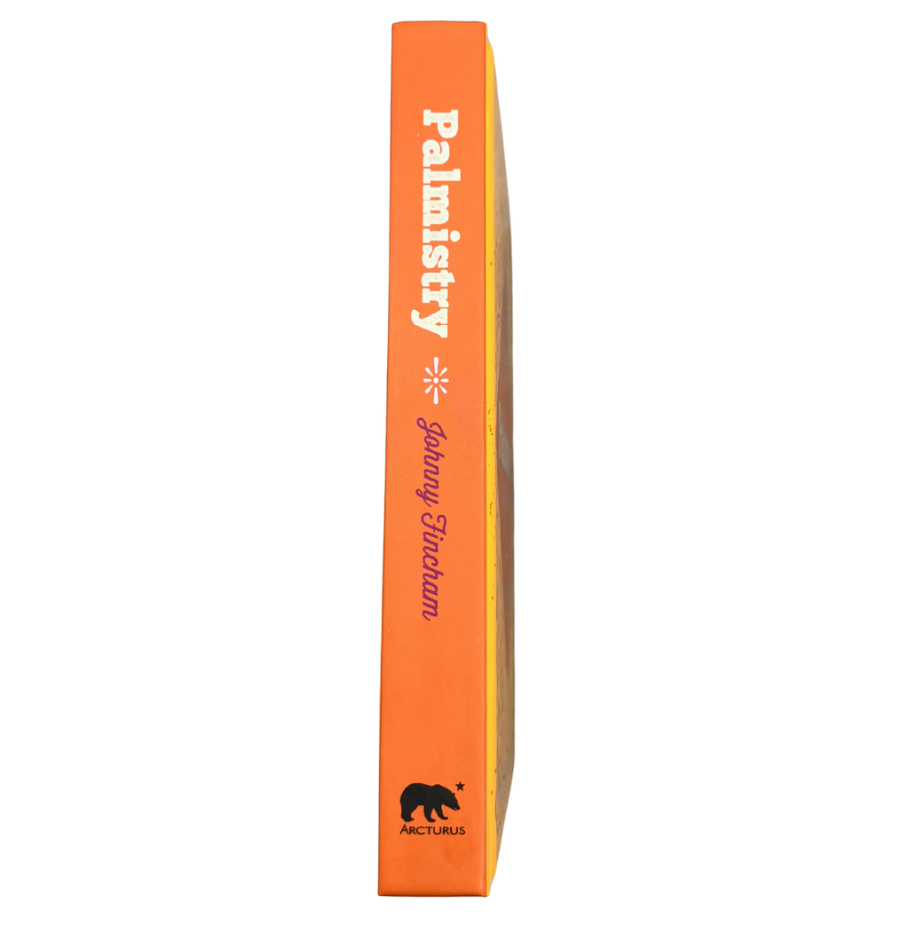 Orange book titled 'Palmistry' with a black bear illustration on a white background